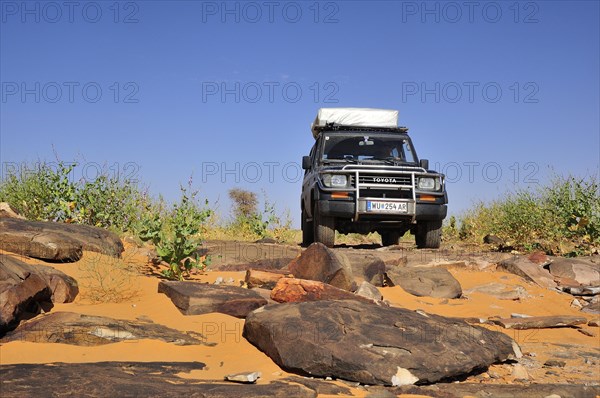 SUV with roof tent on rocky track