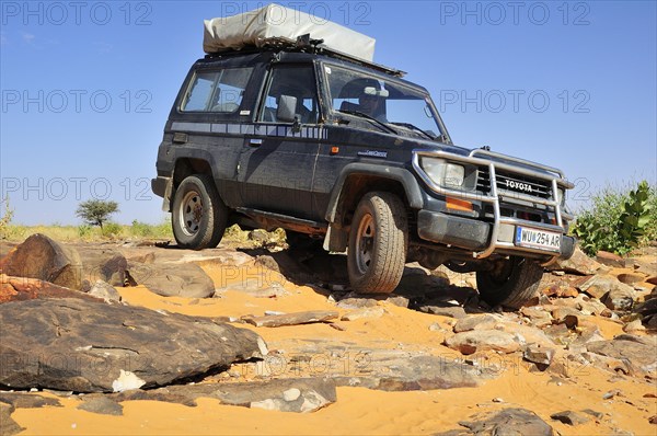 SUV with roof tent on rocky track