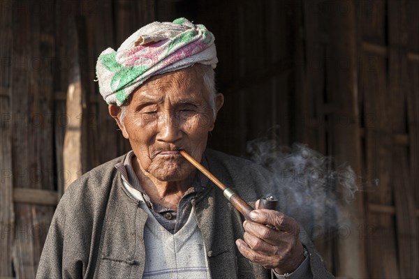 Old local man from the tribe of the Palaung smoking a pipe