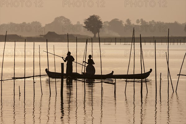 Two people standing in a dugout canoe