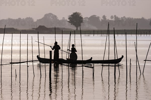 Two people standing in a dugout canoe