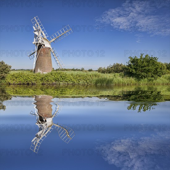 Turf Fen Windmill reflecting in the smooth waters of the Norfolk Broads