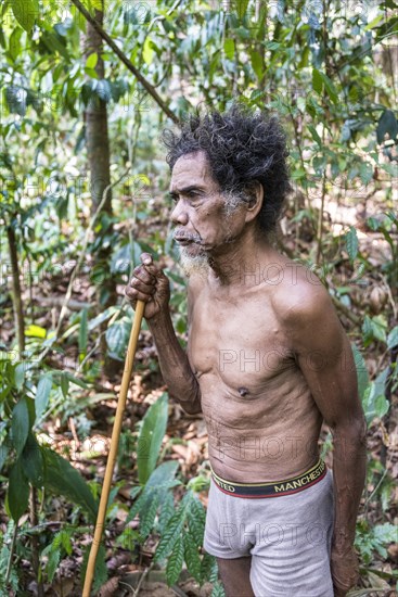 Old Man of the Orang Asil tribe with a blowgun in the jungle
