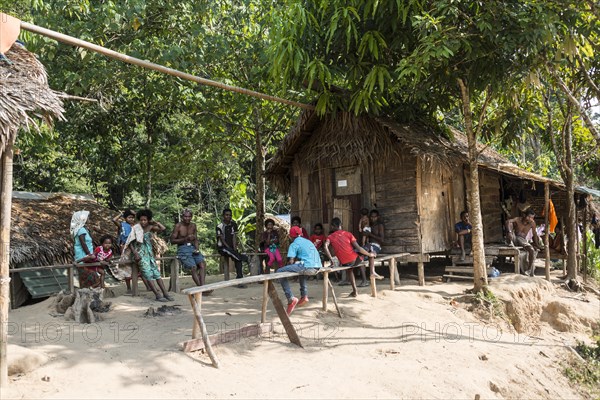 People sitting in front of wooden huts