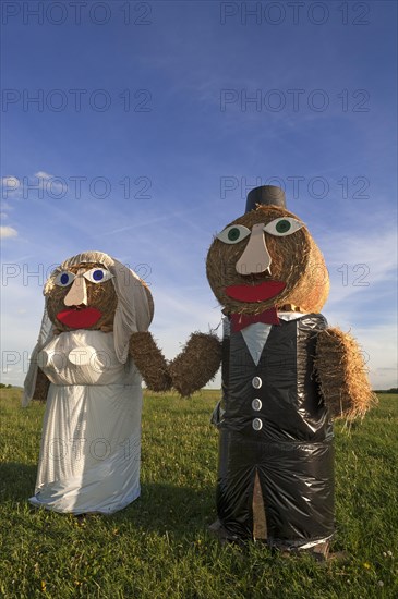 Wedding couple built of straw bales in a meadow