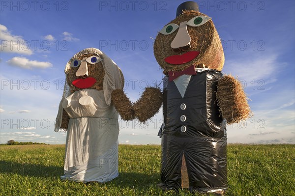 Wedding couple built of straw bales in a meadow