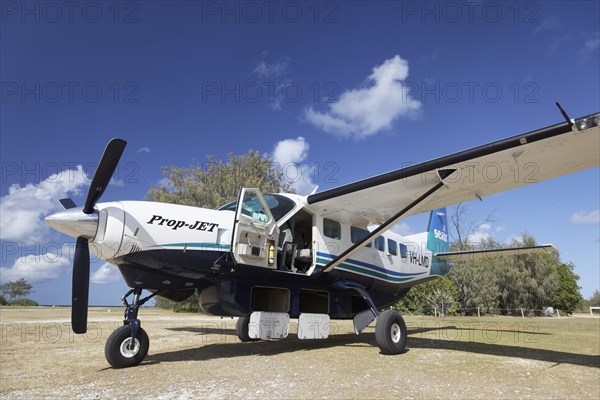 Cessna Caravan 208 Sea Air on unpaved airfield with open underfloor luggage lockers