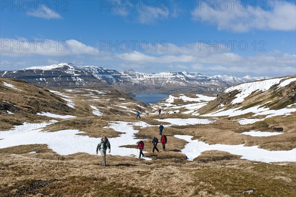 Hikers walking through patches of snow