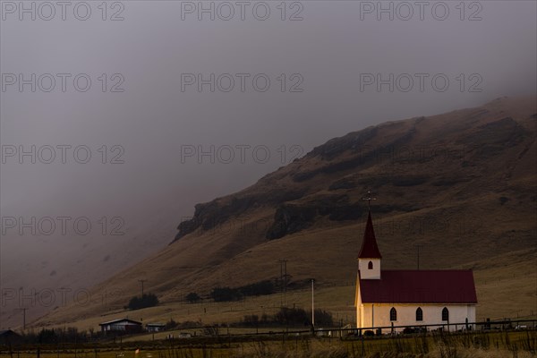 Reyniskirkja church with fog-covered mountains
