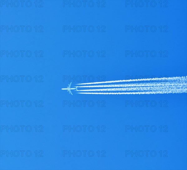 Aibus 380 widebody aircraft of Qatar Airlines with contrails in blue sky