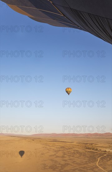 Hot-air balloon above a sandy plain at the edge of the Namib Desert