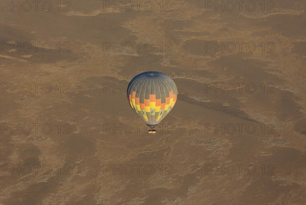 Hot-air balloon above an arid plain at the edge of the Namib Desert