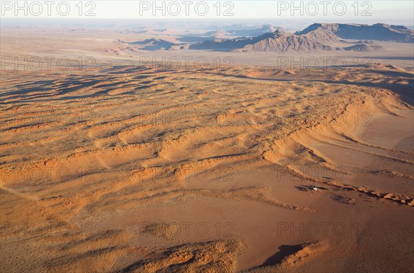 Farmhouse at the foot of a large grass-grown dune at the edge of the Namib Desert