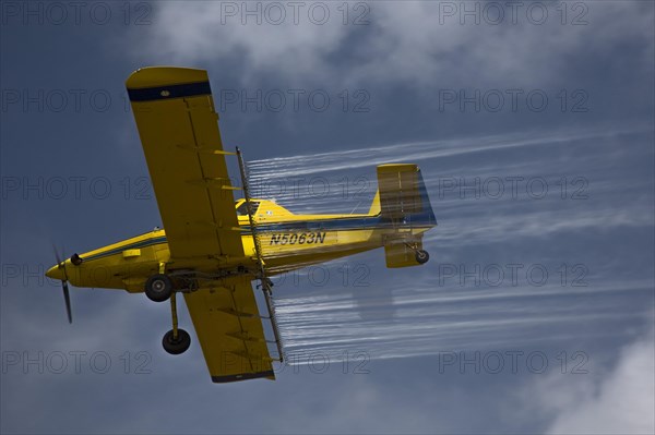 Crop duster airplane applies pesticides to a field in the Mississippi Delta
