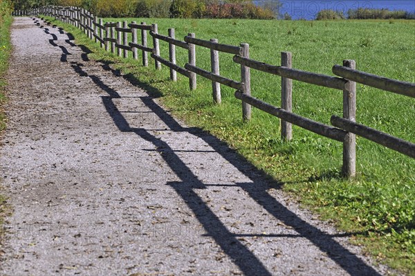 Fence with a shadow along the promenade path