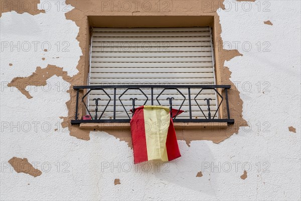 Window with closed blinds and Spanish flag