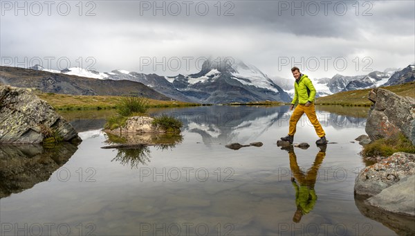 Hiker walks over stones in the water
