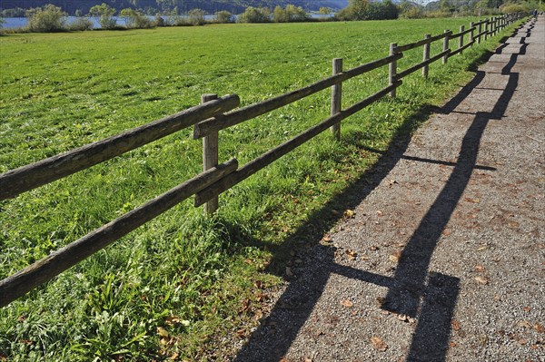 Fence with a shadow along the promenade path