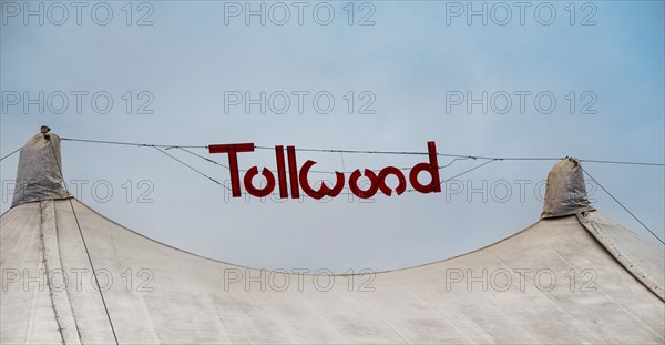 Sign 'Tollwood' above a tent roof