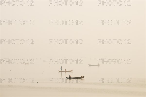 Fishermen in their boats in the morning light