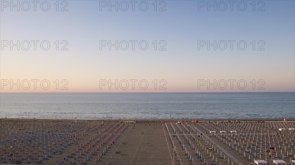 View of a beach with sunshades and sun beds