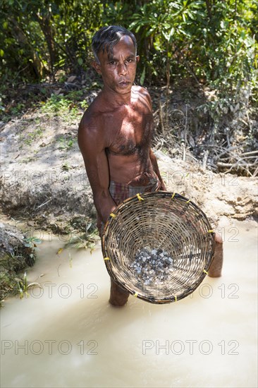 A labourer washing sand to win moonstones