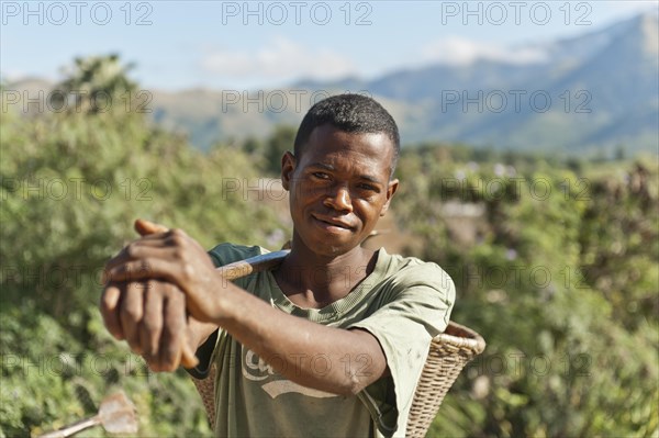 Young man of the Antandroy people carrying a basket for field work