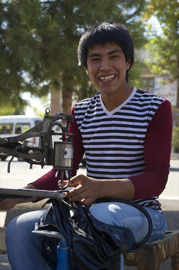 Man working on a sewing machine by the roadside