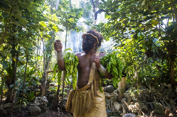 Traditional dressed man with black face in the jungle