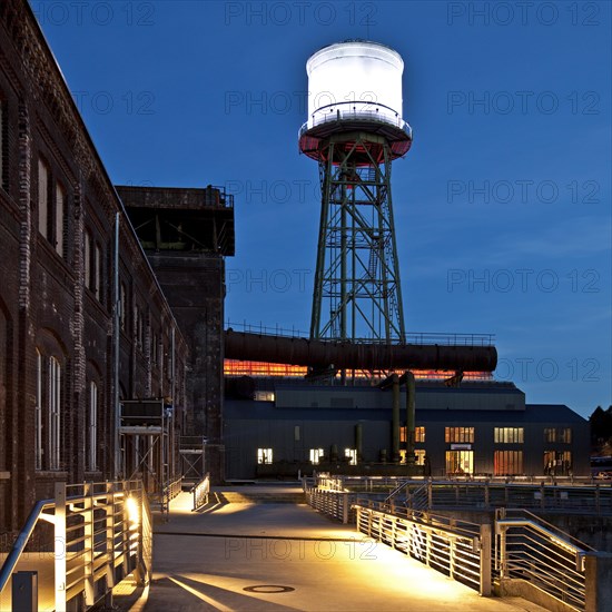 Jahrhunderthalle or Centennial Hall with a water tower at dusk