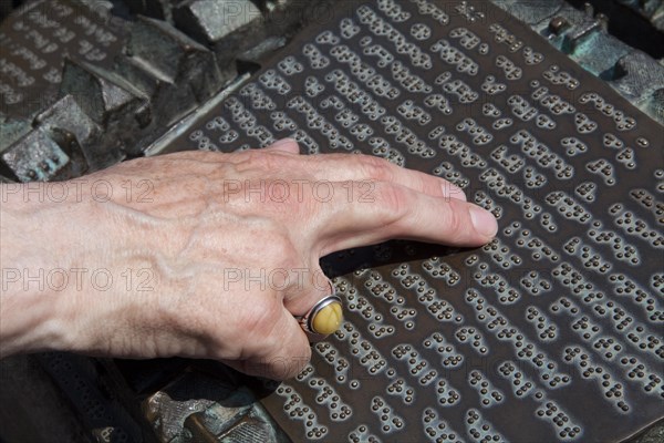 Male fingers reading braille