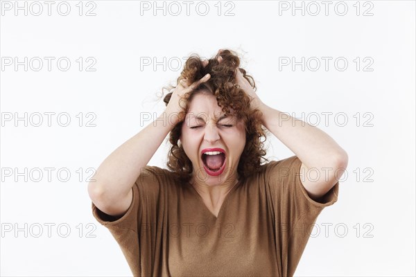 Screaming young woman tearing at her hair