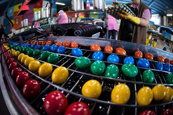Brightly coloured Easter eggs on a conveyor belt