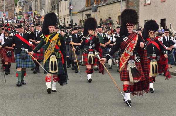 Pipe majors of various pipe bands leading the parade through the town