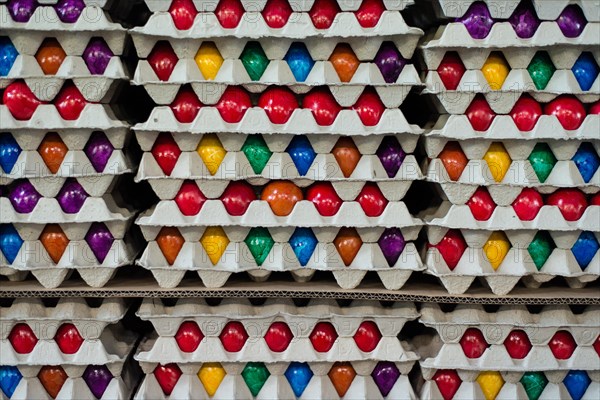 Brightly colored Easter eggs stacked in cardboard boxes