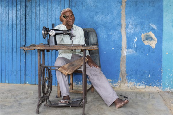 Tailor sitting in front of his shop in Kalabo