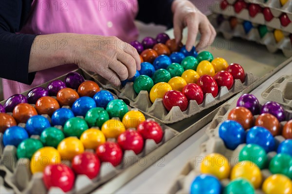 Worker during quality control of colourful dyed Easter eggs