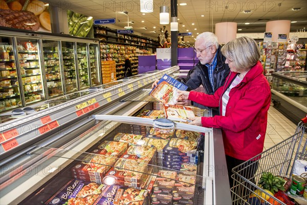 Senior couple shopping in the frozen food section in a supermarket