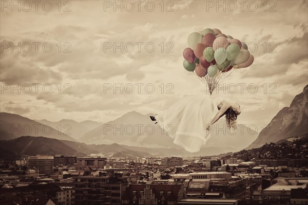 Bride floating on balloons over Innsbruck
