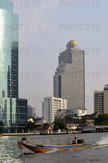 Long-tail boat on the Chao Phraya River with the State Tower at back