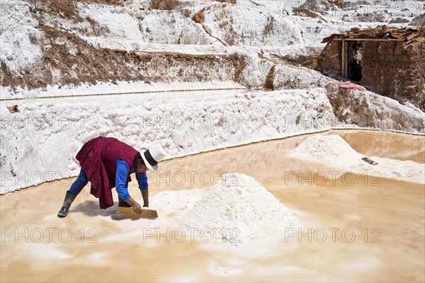 Locals piling up salt with a wooden board