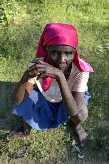 Old woman sitting in the grass