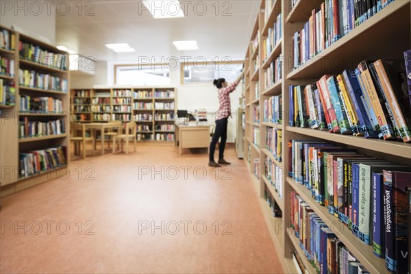 Woman looking for a book in a school library