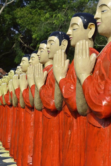 Figures of Buddhist monks in front of a monastery