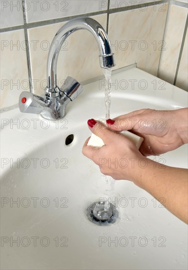 Washing hands with German curd soap in a washbasin