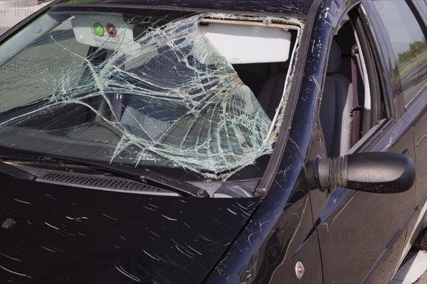 Black compact car with an accident-damaged windshield