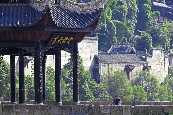 Old woman standing next to the Kuixingge Pagoda