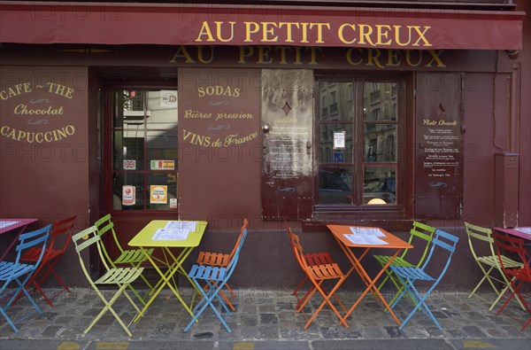 Colourful tables and chairs outside the street cafe 'Au Petit Creux'