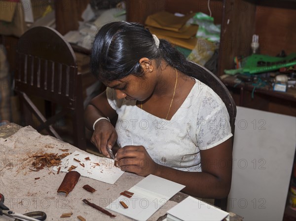 Young woman making wood jewelry