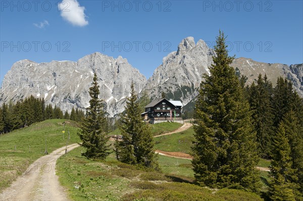 Mountain hut in front of mountain massif